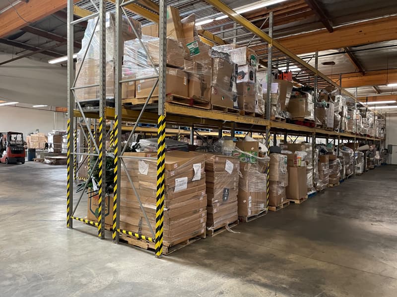 Picture of warehouse inventory with merchandise in towers of boxes wrapped in plastic